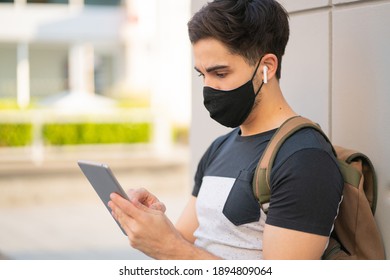 Young man using digital tablet outdoors. - Powered by Shutterstock