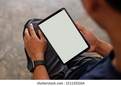 Young man using digital tablet. Blank screen for your text.	