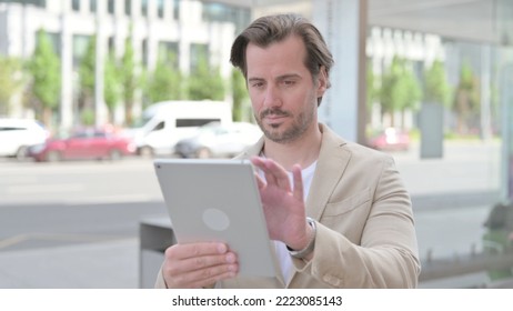 Young Man using Digital Tablet while Standing Outdoor