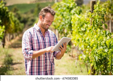 Young man using digital tablet at vineyard on sunny day - Powered by Shutterstock