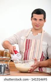 Young Man Using An Electric Egg Beater