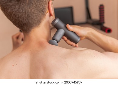 A Young Man Is Using And Enjoying Percussion Massage Gun To Relax And Relief The Pain In Body And Muscles 