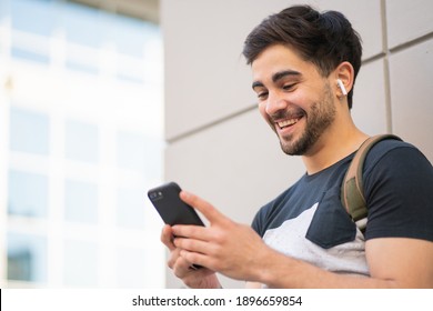 Young man using his mobile phone outdoors.