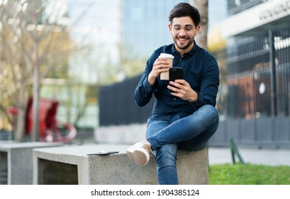 Young Man Using His Mobile Phone Outdoors.