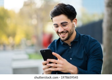 Young Man Using His Mobile Phone Outdoors.