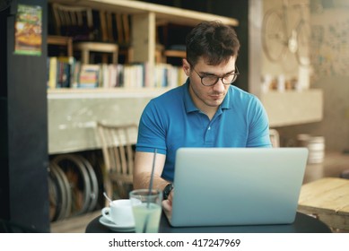 Young man using laptop in a cafe