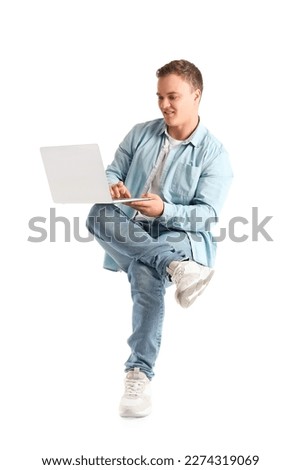 Young man using laptop in chair on white background