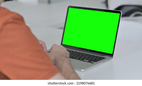 Young Man Using Laptop With Green Chroma Key Screen