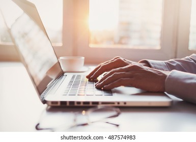 Young Man Using Laptop In Office, Typing On Keyboard. Writer, Journalist Or Student Men Working On Computer At Home. Businessman, Work From Home, Distance Education, Online Learning, Studying Concept