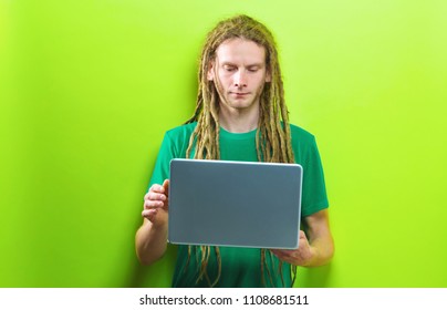 Young Man Using A Laptop On A Solid Color Background