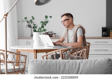 Young man using laptop at table in office