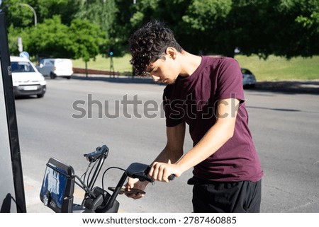A young man using a mobile app to unlock a rental bike