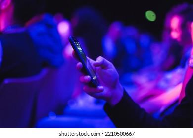 Young man using mobile phone at technology meeting event - Soft focus on front fingers - Powered by Shutterstock