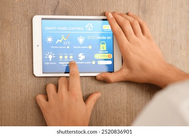 Young man using smart home control panel in kitchen, closeup - Powered by Shutterstock