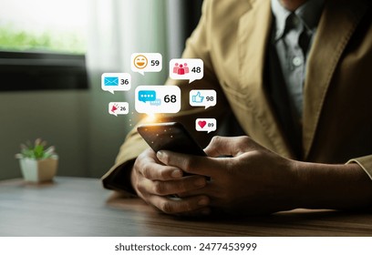 Young Man Using Smartphone with Multiple Social Media Notifications Displayed on Screen, Engaging in Digital Communication and Social Networking, Busy Lifestyle with Technology Interaction - Powered by Shutterstock