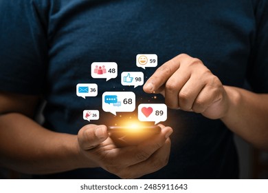 Young Man Using Smartphone with Multiple Social Media Notifications Displayed on Screen, Engaging in Digital Communication and Social Networking, Busy Lifestyle with Technology Interaction - Powered by Shutterstock