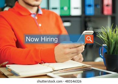 Young man using smartphone and searching NOW HIRING? word on internet