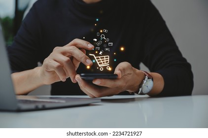 Young man using smartphone with shopping cart icon,  Online shopping and e-commerce concept. - Powered by Shutterstock