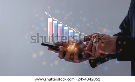 Young man using smartphone to visualize money growth The phone screen displays graphs and charts showing increasing investment and savings trends, along with an increased account balance