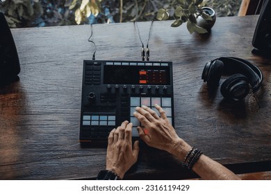 Young man using synth pads, make music