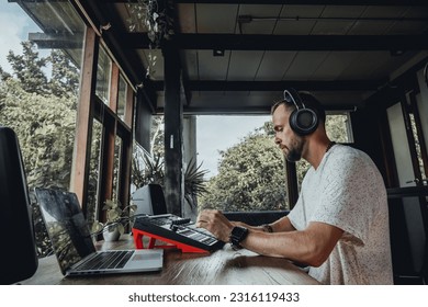 Young man using synth pads, make music