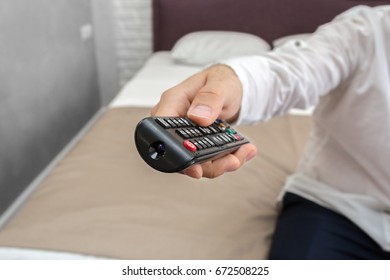 Young man using TV remote control