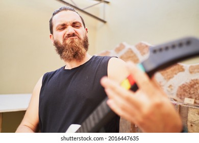 Young Man Using Video Game Toy Guitar To Simulate He Is Playing It