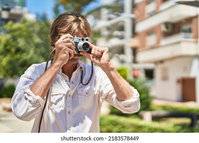 Young Man Using Vintage Camera At Park