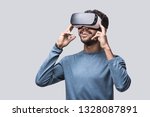 Young man using virtual reality headset. Isolated on gray background studio portrait. VR, future, gadgets, technology, education online, studying, video game concept