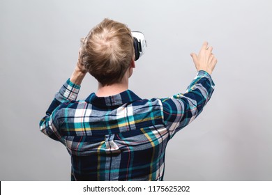 Young Man Using A Virtual Reality Headset From Behind