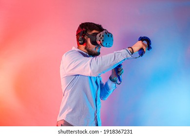 Young man using the virtual reality glasses and two gamepad