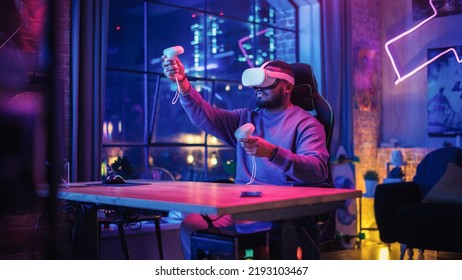 Young Man Using Virtual Reality Headset with Controllers at Home in Loft Apartment. Stylish Black Male Browsing Online, Spending Time in VR Software and Digital Office. POV from Screen Perspective. - Powered by Shutterstock