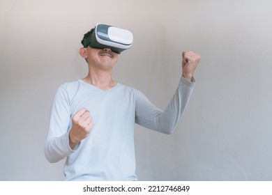 Young Man Using Virtual Reality Headset. Isolated On Grey Background Studio Portrait. VR, Future, Technology, Education Online, Studying . Man Trying To Touch Objects In Virtual Reality , 