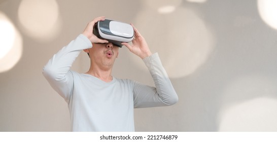 Young Man Using Virtual Reality Headset. Isolated On Grey Background Studio Portrait. VR, Future, Technology, Education Online, Studying . Man Trying To Touch Objects In Virtual Reality , 