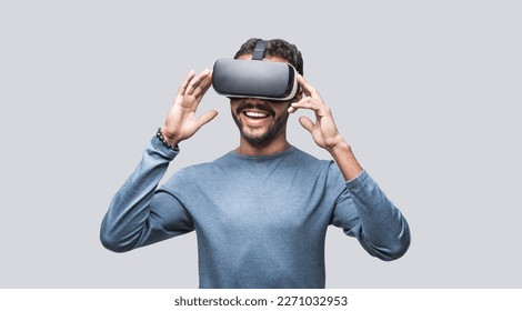 Young man using virtual reality headset. Isolated on gray background studio portrait, VR technology concept - Powered by Shutterstock