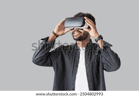 Young man using virtual reality headset. Isolated on gray background studio portrait.