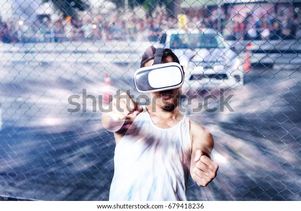 Young Man\
using Virtual Reality Glasses See Simulation image 3D Controller\
while playing video games Car\
Racing