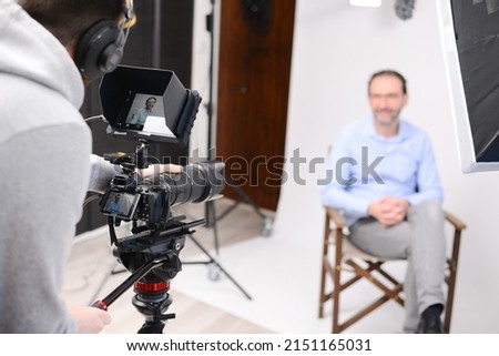young man video camera operator making interview in professionnal broadcast tv movie studio film production