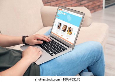 Young Man Visiting Online Dating Site Via Laptop Indoors, Closeup