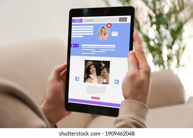Young man visiting online dating site via tablet indoors, closeup