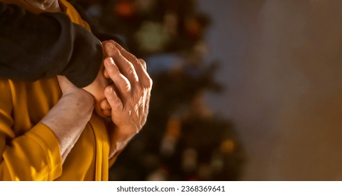 A young man, a volunteer, a son carefully hugs his beloved grandmother, supports and helps an elderly woman in retirement, his grandparent. Young male and female elderly hands with wrinkles closeup.  - Powered by Shutterstock