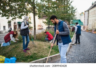 Young Man Volunteer With Team Cleaning Up Street, Community Service Concept