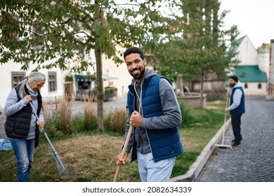 Young man volunteer with team looking at camera and cleaning up street, community service concept - Powered by Shutterstock