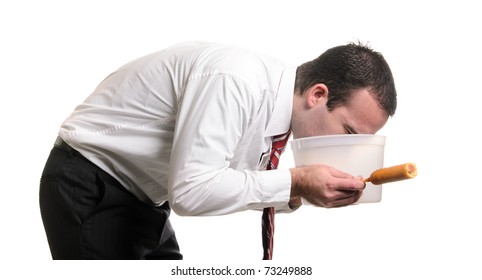 A Young Man Is Vomiting Into A Pail After Eating A Bad Corn Dog And Getting Food Poisoning, Isolated Against A White Background.