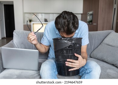 Young Man Vomiting In Rubbish Bin After Exhausting Busy Work Day