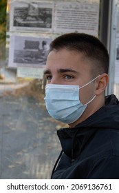 Young Man Waiting At The Bus Stop. Face Mask. Corona Virus. Covis-19.