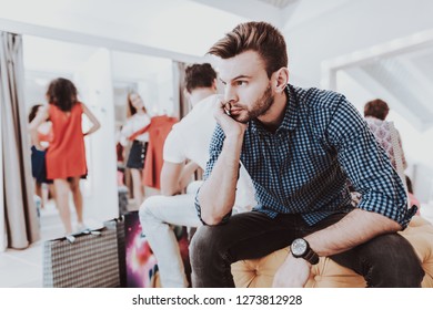 Young Man Waiting For Girlfriend In Dressing Room. Upset Man. Bearded Man. Woman On Shopping. Shopping In Modern Mall. Shopping Concept. Girl In Red Dress. Dressing Room In Boutique.