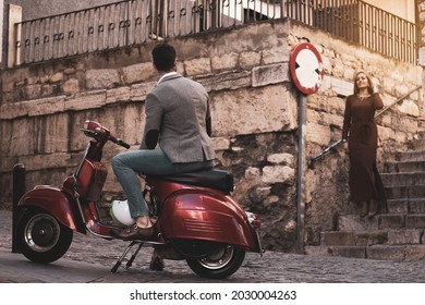 
A Young Man Waiting With His Red Motorcycle For His Girlfriend.