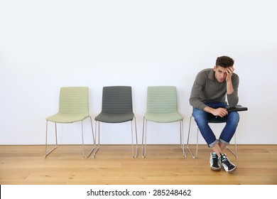 Young Man In Waiting Room For Job Interview