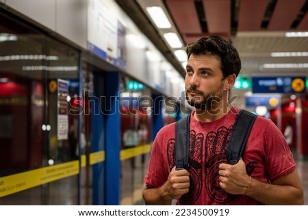 Young man waiting at the subway station. Handsome man in the subway station. Waiting for the subway. Tourist waiting for the subway